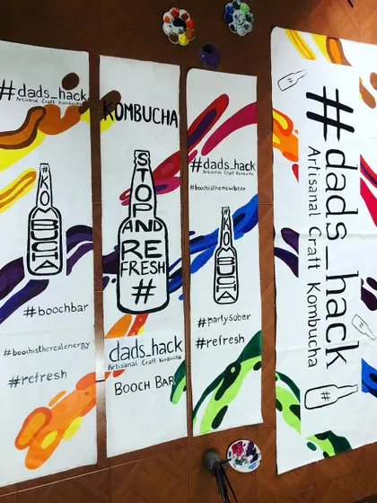 For this project, I hand-painted banners for a kombucha brand on old, discarded banner material. It's a great example of how businesses can align with sustainable practices by reusing materials creatively.