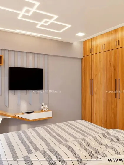 The master bedroom from the 'Konark Oasis' project. The design is modern and minimalistic, with a sleek wooden wardrobe and a compact, floating study desk.
