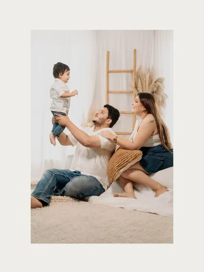 A father lifts his son high in the air as his wife looks on with a smile. These are the joyful, energetic moments that make for unforgettable family photos.