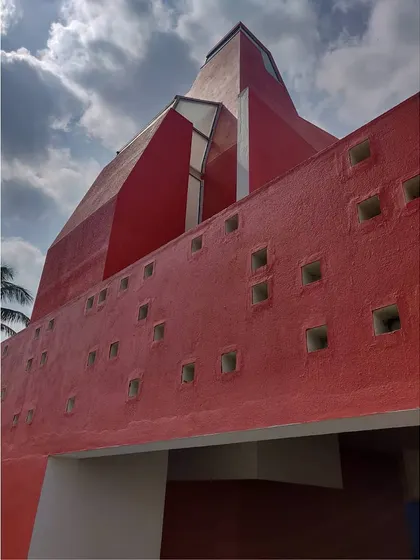 A low-angle view of the temple's 'shikara', showing its abstract, sculptural form and the small, rhythmic openings that allow light to filter into the structure.