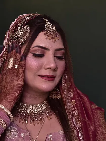 The engagement bride is checking her final look. Her soft glam makeup with shimmery eyes and a beautiful lip color is complete.
