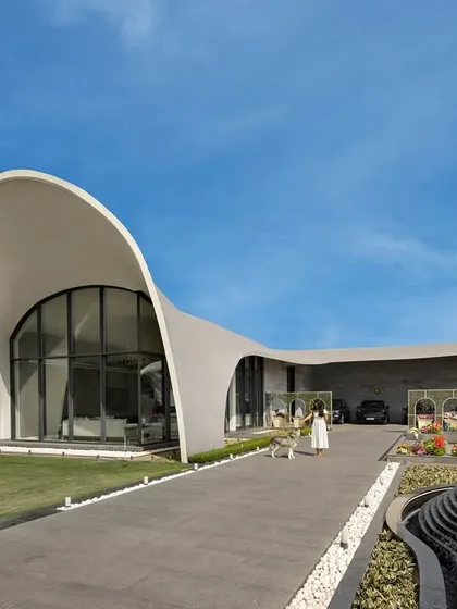 Architecture can be art. For this modern outhouse in Punjab, we designed a structure that emulates the graceful arc of a rising wave. This fluidic form creates a sculptural statement on the landscape, demonstrating our passion for pushing creative boundaries while delivering a functional, awe-inspiring space for entertainment and leisure.