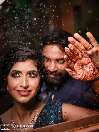 An intimate close-up through a window, focusing on the bride's expression and her intricate henna.