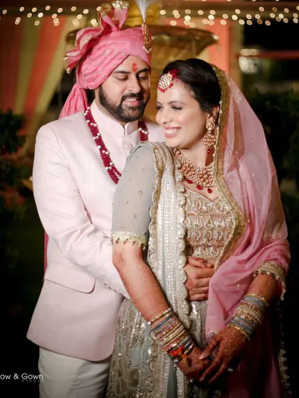 A classic wedding portrait of the couple embracing. Their happy smiles and elegant pastel outfits make this a beautiful and timeless image.