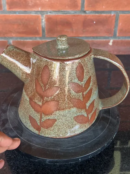 A student created this lovely stoneware teapot during her 15-day combined hand-building and wheel course. The leaf patterns were made using a wax resist technique before glazing.