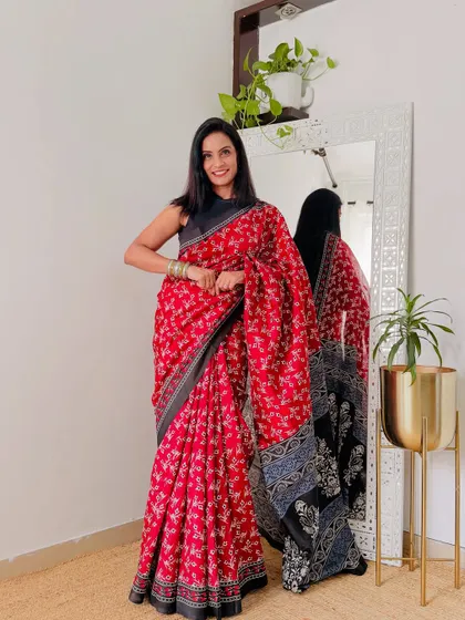A vibrant red printed saree that is perfect for adding a pop of color to your office wear. The black and white printed pallu adds a nice contrast.