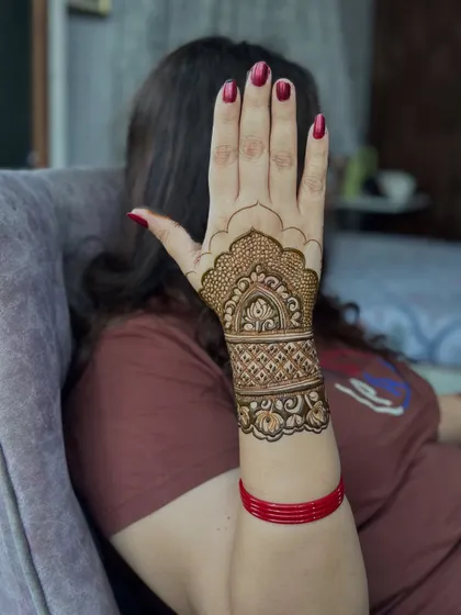 A simple yet elegant design for Karwachauth, covering just the wrist and back of the hand.