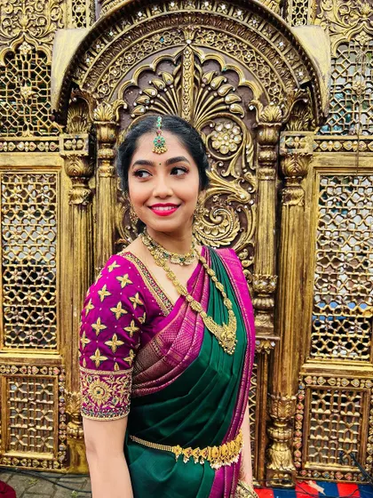 A close-up portrait highlighting the intricate embroidery on her blouse and the flawless makeup application.