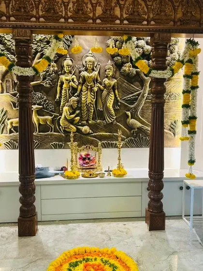 We set up the sacred pooja space for the housewarming ceremony, using traditional marigold and jasmine garlands to frame this beautiful wooden mandap. This pooja mandap decoration is designed to fill the new home with blessings. 💕