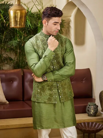 An olive green kurta paired with a meticulously embroidered matching jacket. This earthy tone is a sophisticated choice for a Mehendi ceremony or a festive gathering.