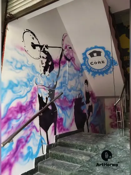 A dynamic, spray-painted mural for Team Core Gym in Gurgaon. The artwork features fitness figures against a colorful, abstract smoke background, creating a sense of movement and energy on the staircase wall.
