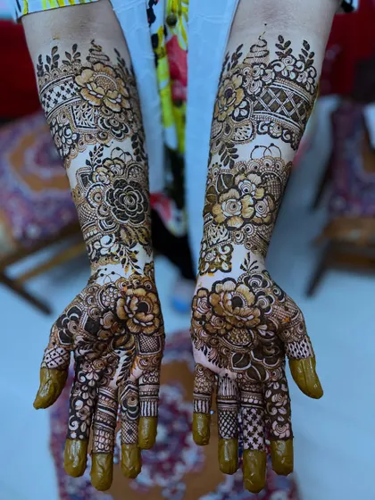 Both hands presented to show the complete, symmetrical floral design. This is the classic bridal pose that showcases the full artwork.