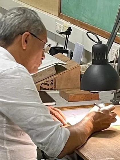 At the drafting table, where ideas first take shape. The act of drawing by hand is fundamental to my practice, a direct connection between thought and form.