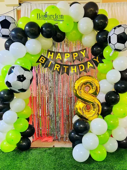 Another take on the football theme, this time with a green, black, and white color scheme and a silver fringe backdrop.