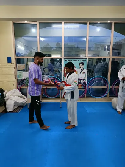 A student receives his red belt.