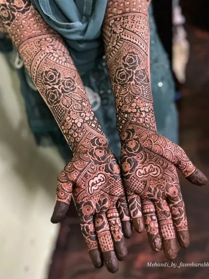 A close-up of the palm work on Rushda's bridal henna, featuring personalized name details hidden within the design.