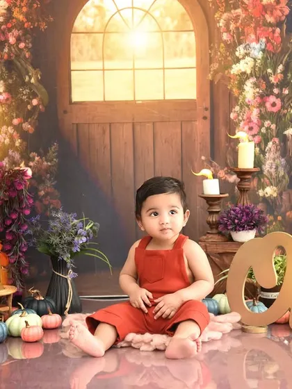 A rustic, warm-toned setup for a little boy's first birthday. The "One" sign and cozy details create a charming and timeless portrait.