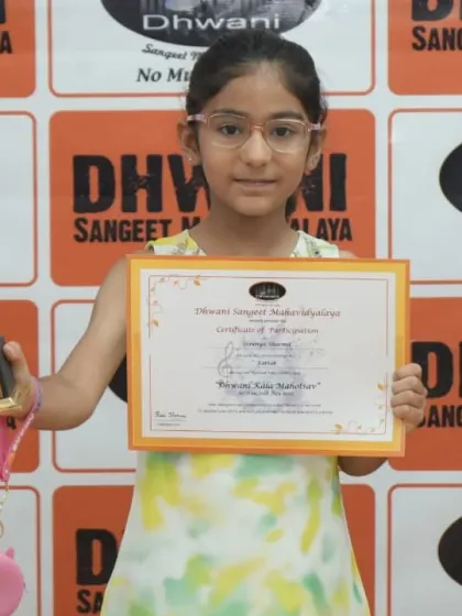 A young student smiles, holding her certificate and trophy.