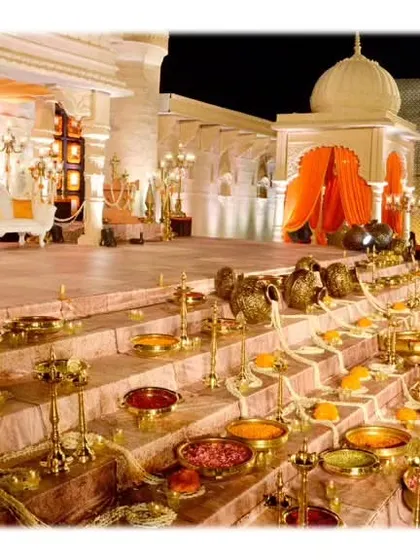 A close-up of the 'ghat' steps, meticulously decorated with brass vessels, colorful powders, and flower petals, recreating an authentic and spiritual ambiance.