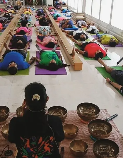 A graduate facilitates a sound bath for a large group. My training prepares you to confidently lead sessions of any size, creating a powerful collective experience.