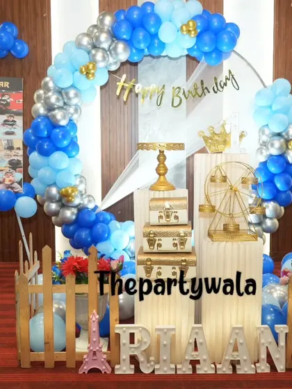 A full view of a blue and silver balloon ring setup, including a personalized photo board.