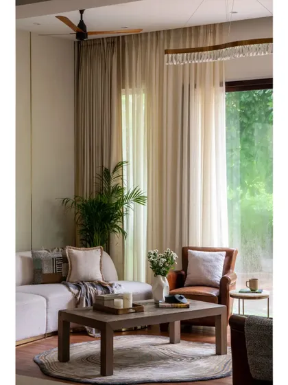 Another view of the living room, highlighting the soft, neutral color palette and the abundant natural light from the large windows. This space was designed to be a serene and welcoming family area.