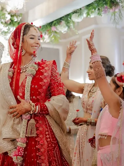 The bride, full of joy, being showered with flowers by her family as she participates in the ceremony.