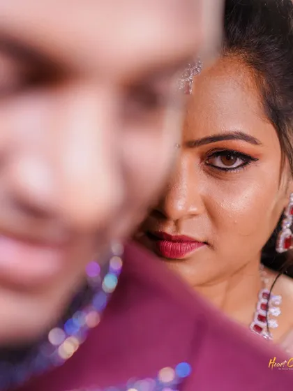 An artistic and intimate close-up. This creative shot focuses on the bride's expressive eyes, with the groom blurred in the foreground.