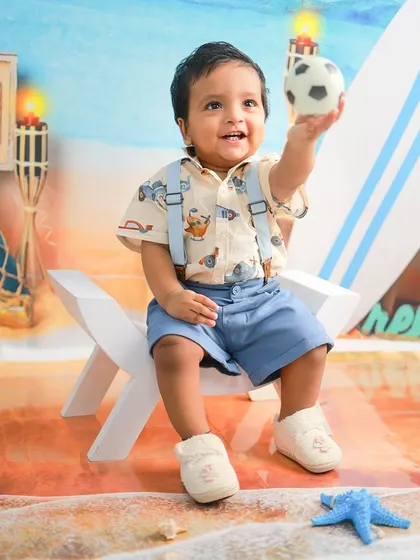 This little guy is ready to play ball at the beach. The candid nature of this shot captures a moment of pure, uninhibited fun.