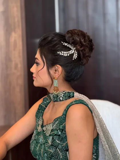 A side profile of the elegant textured updo. The crystal leaf accessory is placed perfectly to accentuate the style without overpowering it.