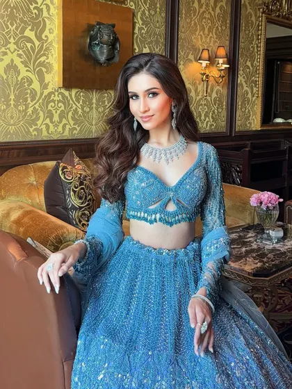 A perfect look for a sangeet or reception. This bride is glowing in a stunning blue lehenga, complemented by soft, wavy hair and diamond jewellery for a touch of modern sophistication.