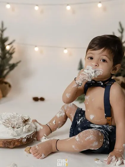 A first taste of birthday cake! This little one is covered in frosting and loving every second of his woodland-themed cake smash session.