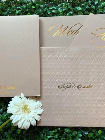 A beautiful set of neutral-toned invitations with a textured finish and elegant gold foil script.