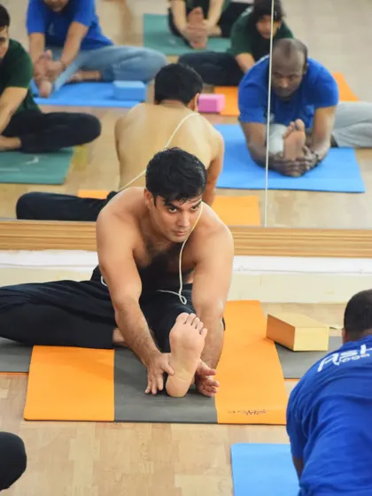 A student in a seated forward bend, reflecting the focus and dedication of our Hatha yoga classes.