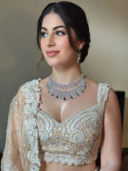 Soft, angelic, and radiant for Ozlem's Sangeet. We created a luminous look with a clean, elegant updo to complement her stunning ivory and silver lehenga.