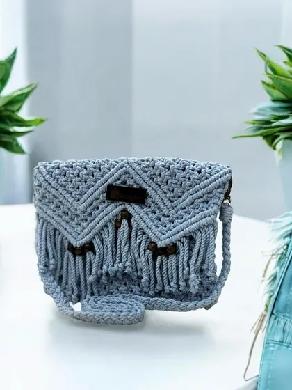 This light grey sling bag with dark wooden beads is perfect for a minimalist yet chic look. It's lightweight and just the right size for your phone and wallet.
