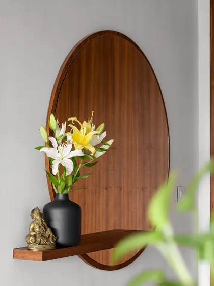 We introduced our 'Gulmohar' project with this image of the foyer. The oval wooden mirror and floating shelf create a simple, auspicious, and warm welcome.