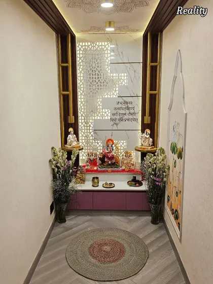 A wider view of the completed mandir, showing the herringbone-patterned flooring and the circular jute rug that grounds the sacred space.