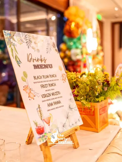 I create themed menus for my events, like this drinks menu for the safari party, featuring cute animal illustrations and creative drink names like 'Black Plum Punch'.