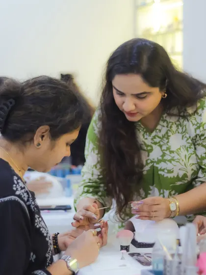 Dipika Parihar teaching a student the finer points of nail art. Her passion for teaching is evident in every interaction.