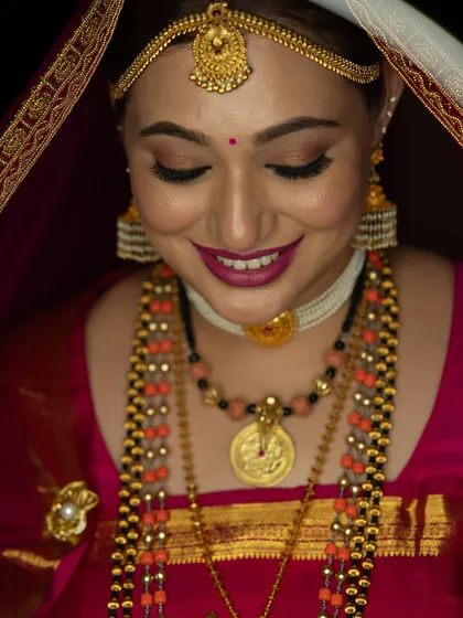 A detailed shot of the bride's makeup, with a focus on her shimmery eyeshadow and beautiful berry-toned lipstick.