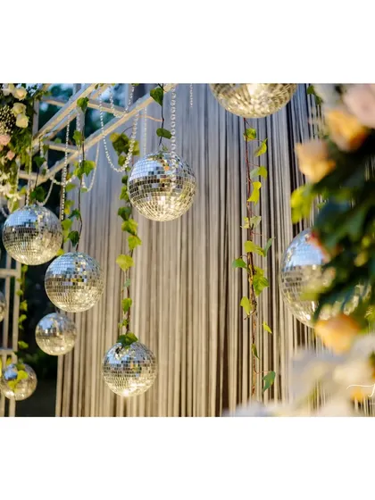 A close-up of the disco balls and green creepers, showcasing the details of the glamorous and nature-inspired Sangeet decor.