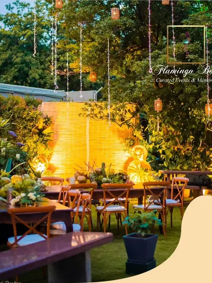 The backyard setting at night, transformed into a magical dining space. The warm light from the bamboo backdrop and hanging fairy lights created a cozy and inviting atmosphere.