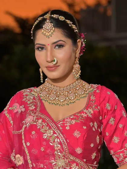 A complete bridal look featuring a heavy, gold-plated Kundan necklace, haath phool, and maang tikka, all available for rent.
