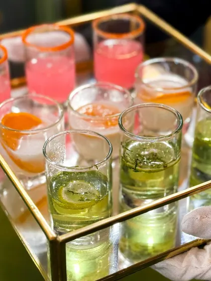 A tray of assorted welcome drinks, featuring different colors and flavors to greet guests as they arrive.