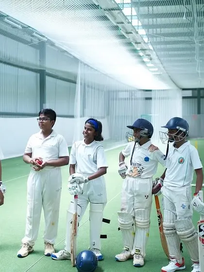 Our coaches create a positive and engaging atmosphere. Here, a group of young cricketers listens intently during a strategy talk in our indoor facility.