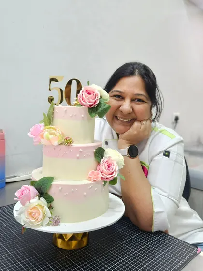 A proud moment with an elegant, three-tier floral cake for a 50th birthday.