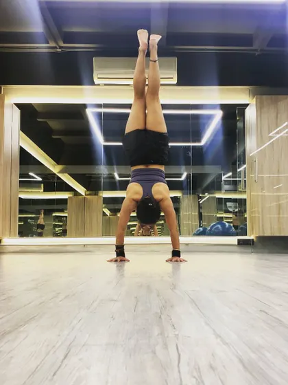 A handstand practice moment. The feeling of balancing on your hands is incredibly empowering. We use the wall and other props to build confidence for this pose.