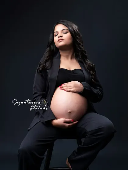 A seated portrait that feels both strong and serene, focusing on the beautiful shape of the baby bump.