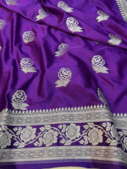 A close-up shot of the purple Mashru silk saree, highlighting the fine craftsmanship of the silver zari work. The fabric has a soft sheen that is characteristic of authentic Mashru silk.